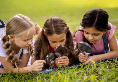 girls-looking-grass-through-magnifying-glass