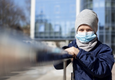 front-view-child-posing-outside-with-medical-mask_23-2148501278